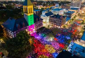 Aerial view at night of the Cambridge Dance Party, building and crowd illuminated by colorful lights