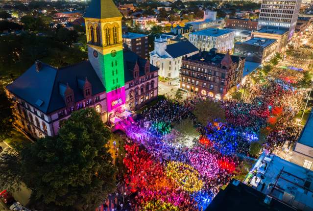 Aerial view at night of the Cambridge Dance Party, building and crowd illuminated by colorful lights