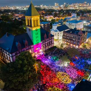Aerial view at night of the Cambridge Dance Party, building and crowd illuminated by colorful lights