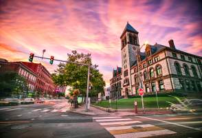 Stylized image of Cambridge buildings with purple sunset behind them