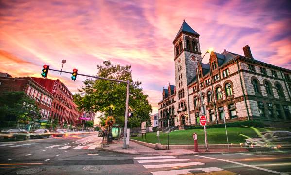 Stylized image of Cambridge buildings with purple sunset behind them