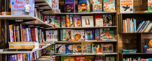 Two walls with floor to ceiling bookshelves filled with children's books at the Frugal Bookstore